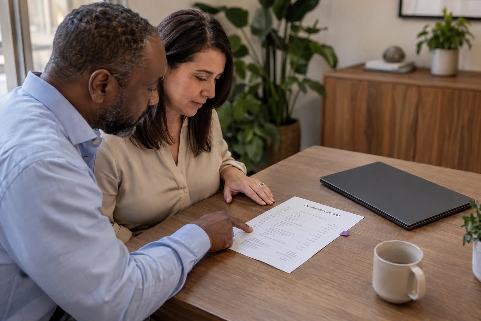 Two business principals review an agreement and delivery plan together.