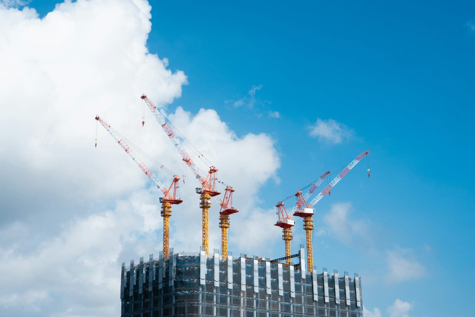 Tower cranes above a high-rise under construction