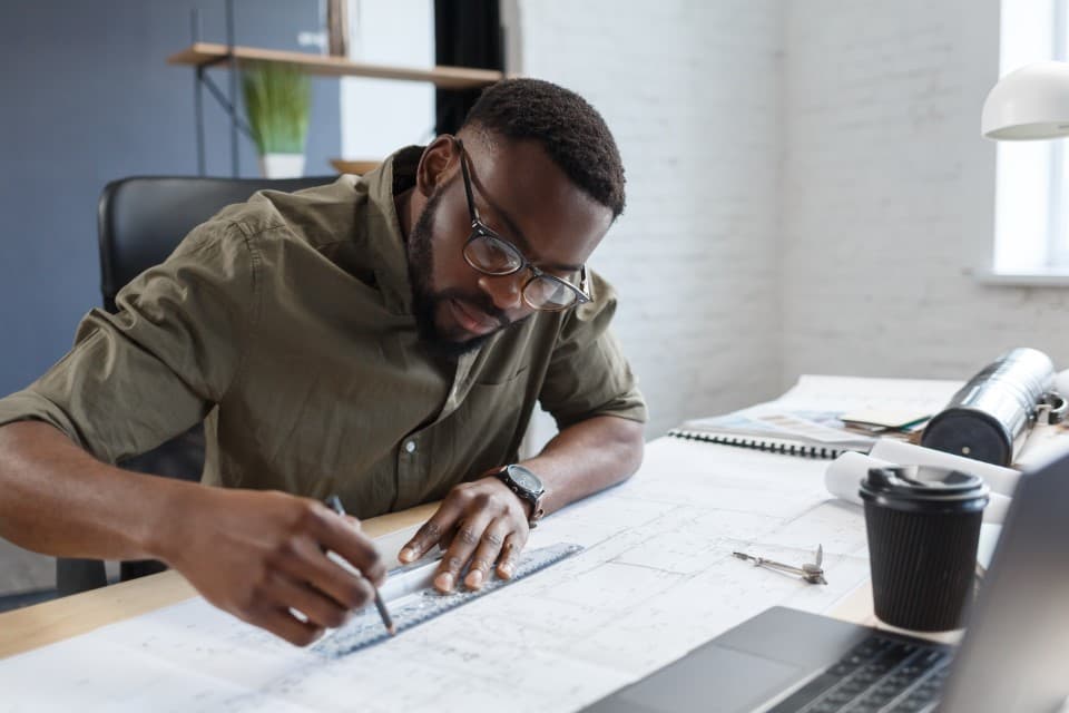 A consultant drafting technical plans at a desk